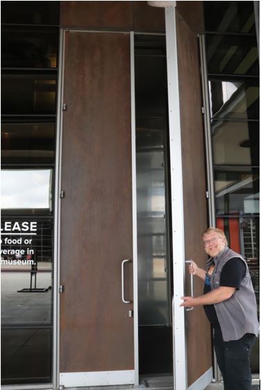 Gary opening a huge door at the Harley Davidson Museum