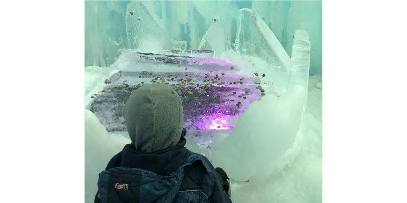 A child looking at lights in ice