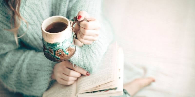 Reading a book and enjoying a cup of coffee