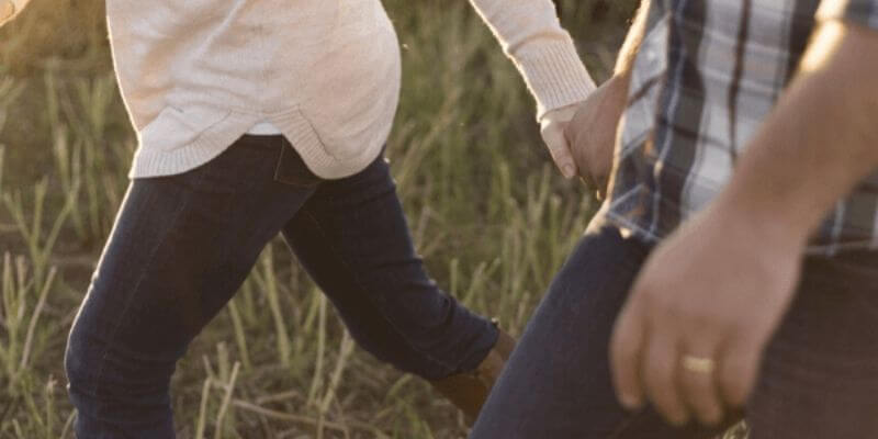 un couple qui marche en se tenant la main. mains