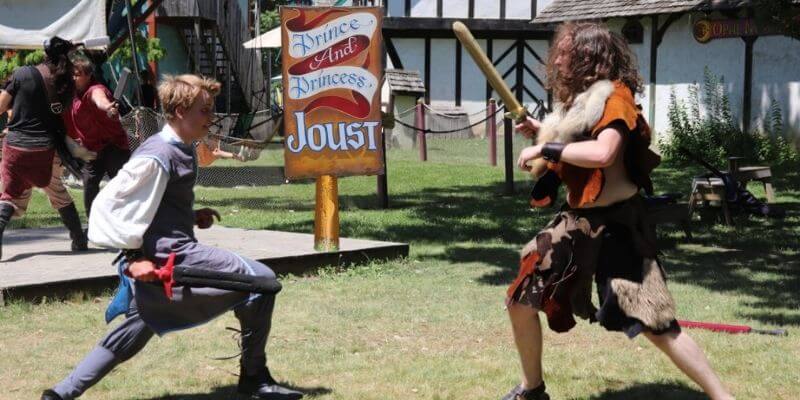 two faire goers jousting