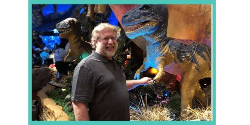 Gary shaking hands with a dinosaur